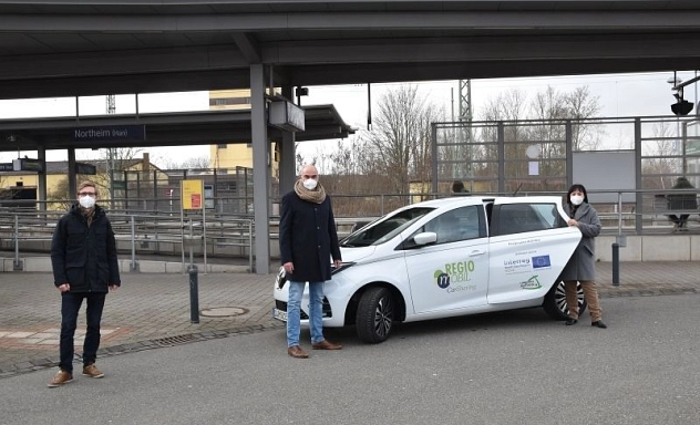 201/2021 - MOPINO dritte Ladesäule am Bahnhof Uwe Zimmermann (RegioMobil), Northeims Bürgermeister Simon Hartmann und Landrätin Astrid Klinkert-Kittel zeigen das neue E-Auto, das für Carsharing am Northeimer Bahnhof genutzt werden kann.