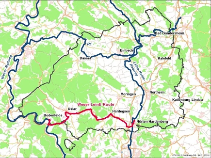 Das Foto zeigt einen Kartenausschnitt, in dem der Landkreis Northeim mit den drei vorhandenen Fernradwegen zu sehen ist. Südlich in rot ist die geplante Verbindung, die „Weser-LeinE-Route“ eingezeichnet, die von Bodenfelde bis Nörten-Hardenberg reicht. © Landkreis Northeim
