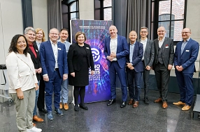 Eine Gruppe von zwölf Personen steht gemeinsam vor einem farbenfrohen Roll-up mit dem Schriftzug „Innovationspreis Region Göttingen Northeim“. Die Veranstaltung fand in einem modernen, lichtdurchfluteten Raum mit großen Fenstern statt. Die Teilnehmenden – Vertreterinnen und Vertreter aus Wirtschaft, Verwaltung und Institutionen – posieren gut gelaunt für ein Gruppenfoto. Alle sind geschäftlich gekleidet, einige tragen Namensschilder. Das Roll-up im Hintergrund verweist auf den Wettbewerb für Gründer*innen, Unternehmen und Institutionen aus der Region.&nbsp;&copy;&nbsp;Landkreis Northeim