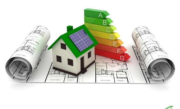 Ein kleines Modellhaus mit grünem Dach und Solarpanel liegt auf ausgerollten Bauplänen. Links und rechts daneben sind weitere Baupläne aufgerollt. Rechts vom Haus steht eine farbige Energiebewertungsskala von grün (A, sehr effizient) bis rot (G, wenig effizient). Unten rechts ist das Logo des Landkreises Northeim zu sehen.