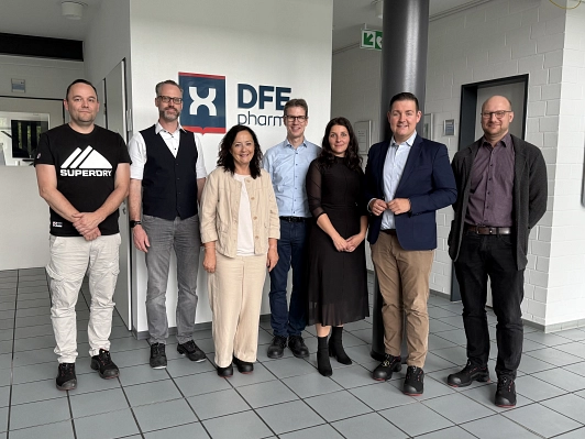 Zu sehen sind sieben Personen die im Foyer des Unternehmens DFE Pharma stehen und in die Kamera schauen. Zu sehen sind (v.l.n.r.): Helge Lüttich (Fachkraft für Arbeitssicherheit), Dr. Georg Platz (Produktionsleiter), Astrid Klinkert-Kittel (Landrätin Landkreis Northeim), Gerhard Windecker (Werkleiter), Aniela Wucherpfennig (Personalleitung), Marcel Riethig (Landrat Landkreis Göttingen), Marcel Diederich (Geschäftsführer WRGN)&nbsp;&copy;&nbsp;Landkreis Northeim