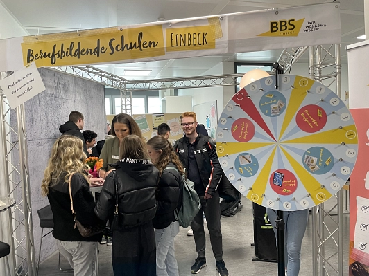 Am Stand der BBS Einbeck steht ein großes Glückrad, auf dem Gewinne verzeichnet sind.
