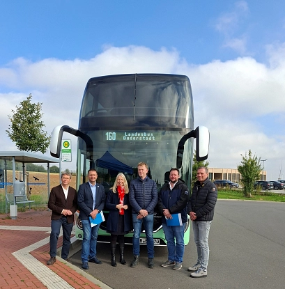 Sechs Personen stehen vor einem großen Doppeldeckerbus mit der Aufschrift 160 Landesbus Duderstadt. Sie posieren für ein Gruppenfoto an einer Bushaltestelle bei sonnigem Wetter. Im Hintergrund sind ein Fahrradständer, Bäume und Gebäude zu sehen.&nbsp;&copy;&nbsp;ZVSN
