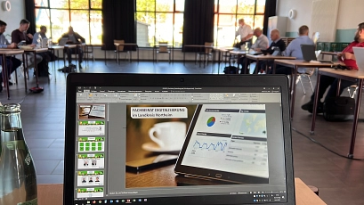 Das Bild zeigt einen Laptop und im Hintergrund eine Sitzung des Fachbeirates Digitalisierung&nbsp;&copy;&nbsp;Landkreis Northeim