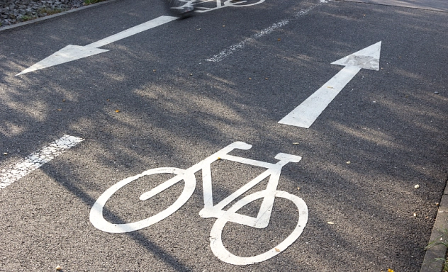 Fahrradweg Auf dem Bild ist ein zweispuriger Fahrradweg zu sehen mit weißen Markierungen.