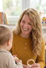 Eine Frau sitzt an einem Tisch einem kleinen Kind gegenüber und hält ein Spielzeug in der Hand.&nbsp;&copy;&nbsp;Anne Lixfeld