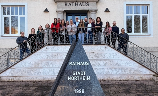 Gruppenbild Runder Tisch Radverkehrsförderung Gruppenfoto vor dem Rathaus der Stadt Northeim: Auf der Treppe stehen Vertreterinnen und Vertreter der Kommunen und der Kreisverwaltung; im Vordergrund ist ein Stein mit der Aufschrift „Rathaus Stadt Northeim“.