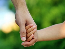 Kinderschutz Zu sehen sind zwei Hände, Hand in Hand. Es ist eine Erwachsenen Hand und eine Kinder Hand.
