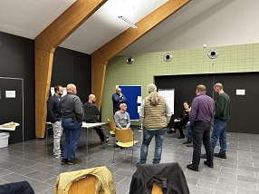 Kleine Diskussionsrunde beim 1. Digitalisierungsbarcamp Vor einem Clipboard haben sich in einer Ecke des Raumes einige Teilnehmende zu einem Gespräch versammelt. Einige Personen stehen, andere sitzen auf Stühlen. © Landkreis Northeim