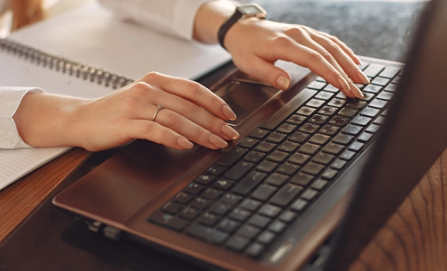 Laptop Computer Work Online Zu sehen ist eine Laptop Tastatur auf der jemand tippt