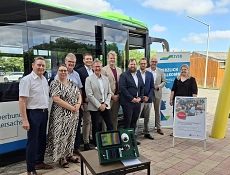Pressetermin_Fahrgastzählsystem_20260629 Zehn Personen – eine Frau und neun Männer – stehen vor einem Linienbus des Verkehrsverbunds Süd-Niedersachsen (ZVSN) und posieren für ein Gruppenfoto. Vor ihnen ist ein automatisches Fahrgastzählsystem mit Kamera- und Sensortechnik auf einem Tisch aufgebaut. Im Hintergrund stehen ein ZVSN-Roll-up sowie ein Informationsaufsteller zum Projekt. Die Aufnahme entstand bei der Vorstellung der neuen Fahrgastzählsysteme für den öffentlichen Nahverkehr.