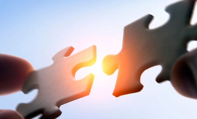 Zu sehen sind zwei Puzzleteile, die zusammengesteckt werden.