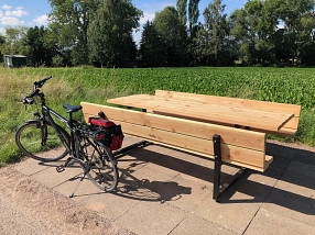 Vor dem Hintergrund einer Wiese und Bäumen steht eine Tisch-Bank-Kombination aus Holz. Davor steht ein Fahrrad.&nbsp;&copy;&nbsp;Landkreis Northeim