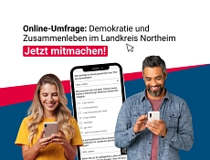 Titelbild Umfrage Demokratie und Zusammenleben im Landkreis Northeim Zu sehen sind zwei Personen mit je einem Smartphone in der Hand, hinter Ihnen ist überlebensgroß ein Bild von einem Smartphone montiert. Der Text auf dem Bild lautet: Online-Umfrage: Demokratie und Zusammenleben im Landkreis Northeim, jetzt mitmachen!
