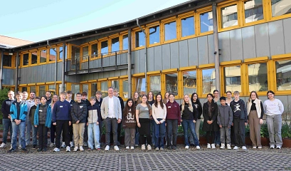 Zu sehen sind die Schülerinnen und Schüler, die anlässlich des Zukunftstages die Kreisverwaltung besucht haben, Martin Brünig, Dezernent für Kreisentwicklung (mittig, graues Sakko), die Ausbildungsleitung Anessa Dittrich (zweite von rechts) sowie einige der Nachwuchskräfte der Kreisverwaltung, die den Zukunftstag betreuen. Sie stehen vor dem Anbau der Kreisverwaltung und schauen alle in die Kamera.&nbsp;&copy;&nbsp;Landkreis Northeim