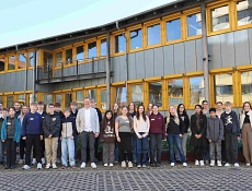 Zukunftstag 2026 Kreisverwaltung Zu sehen sind die Schülerinnen und Schüler, die anlässlich des Zukunftstages die Kreisverwaltung besucht haben, Martin Brünig, Dezernent für Kreisentwicklung (mittig, graues Sakko), die Ausbildungsleitung Anessa Dittrich (zweite von rechts) sowie einige der Nachwuchskräfte der Kreisverwaltung, die den Zukunftstag betreuen. Sie stehen vor dem Anbau der Kreisverwaltung und schauen alle in die Kamera.